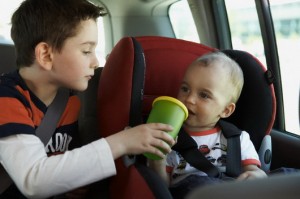 Boy Giving Brother Drink of Water